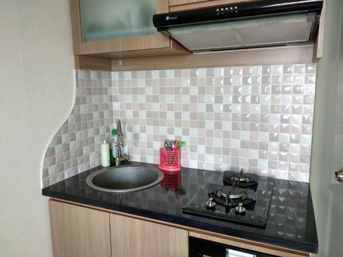 een keuken met een wastafel en een fornuis bij Apartment comfy 2 BR Scarlet in Jakarta