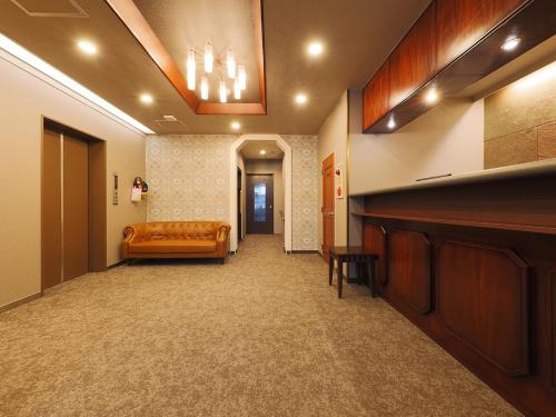 a waiting room with a couch in the middle of a room at Matsue Urban Hotel Lake Inn in Matsue