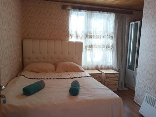 a bedroom with a bed with two green shoes on it at Sweetnight in Mestia