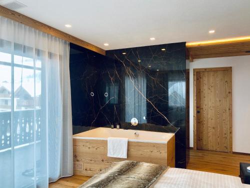 圣维吉利奥Florisa Mountain Penthouse的带浴缸和黑色墙壁的浴室