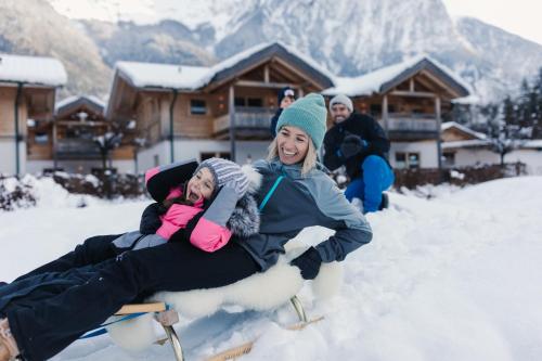 a group of people riding on a snowledge at Feelfree Nature Resort in Oetz