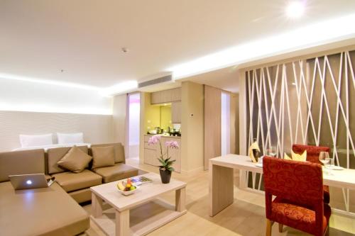 a living room with a couch and a table at The Stay Hotel "SHA Certified" in Pattaya
