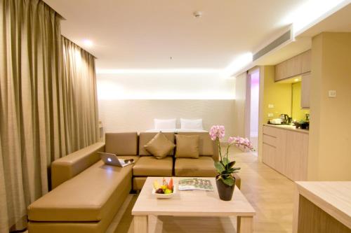 een woonkamer met een bank en een tafel bij The Stay Hotel "SHA Certified" in Pattaya