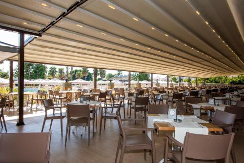 un ristorante con tavoli e sedie bianchi e finestre di Side Star Resort Hotel - Ultra All Inclusive a Side