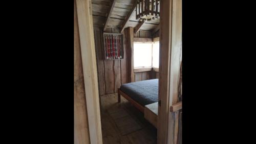 a small room with a bed and a window at Wonderful rustic cabin 2, with native logs, on the banks of the Trancura River in Pucón