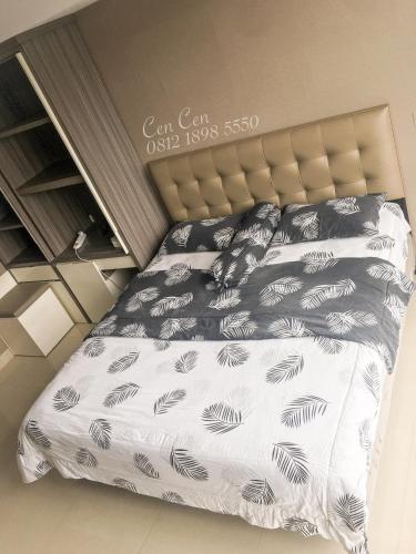 a bed with black and white sheets and pillows at Near Aryaduta, Siloam Hospital, UPH. U Residence Apartment for Stay in Tangerang