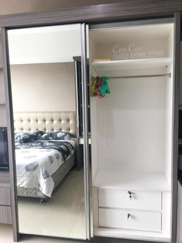 a bedroom with a mirror next to a bed at Near Aryaduta, Siloam Hospital, UPH. U Residence Apartment for Stay in Tangerang