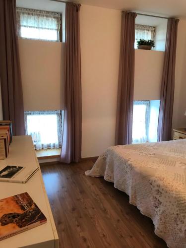 a bedroom with a bed and two windows at Beim-Hofbauer in Tittmoning