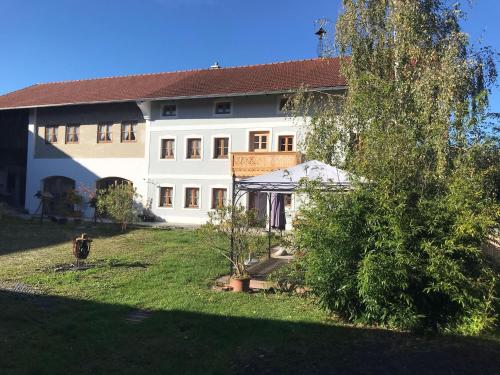 un gran edificio blanco con un árbol en el patio en Pferdehof-Dietzsch en Tittmoning