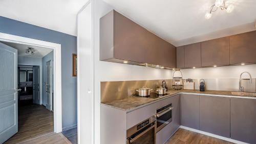 une cuisine avec des armoires marron et un comptoir dans l'établissement The View - Apt 09 - BO Immobilier- Châtel - Multipass 2025 offert, à Châtel