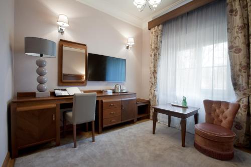 a hotel room with a desk and a chair at Pałac Cieleśnica in Cieleśnica