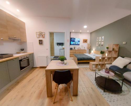a kitchen and a living room with a couch and a table at NOAR Apartment, NEW STUDIO in Orešje