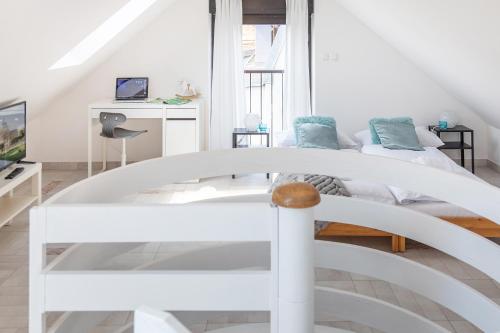 a white bedroom with a bed and a tv at Rooms 88 in Zagreb