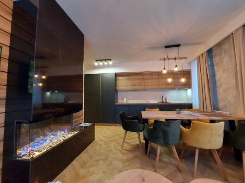 a kitchen and dining room with a dining table and an aquarium at Apartmani Winner Jahorina in Jahorina