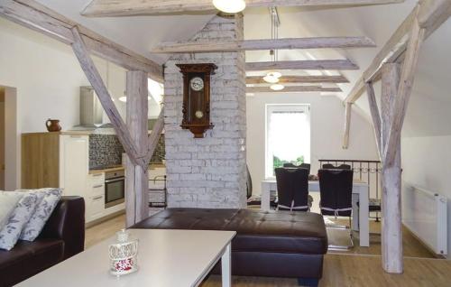 a living room with a couch and a clock in a room at Apartmaji Čujež in Rečica ob Savinji