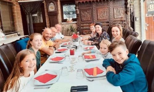 a group of people sitting at a table in a restaurant at B&B Casa Roman & Vakantiewoning voor 1 pers tot max 32 personen in Zonhoven