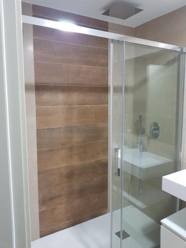 baño con ducha y puerta de cristal en ROMERO APARTMENTS-SUNSET WAVES-BENIDORM, en Benidorm