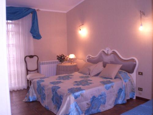 a bedroom with a bed and a chair at Il Glicine di Carmen in Fondi