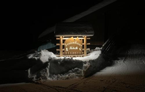 a sign in the snow in front of a building at Ferienhaus Köck in Kartitsch