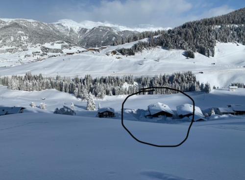 a view of a snow covered mountain with a house at Ferienhaus Köck in Kartitsch
