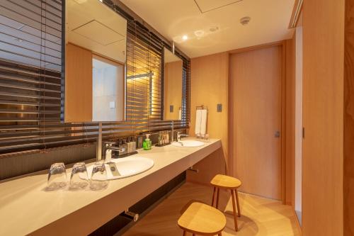 baño con 2 lavabos y espejo grande en Lime Resort Myoko, en Myoko