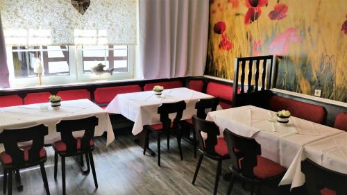 un restaurante con 2 mesas y sillas con mantel blanco en Gasthaus Köhlerhof, en Delliehausen