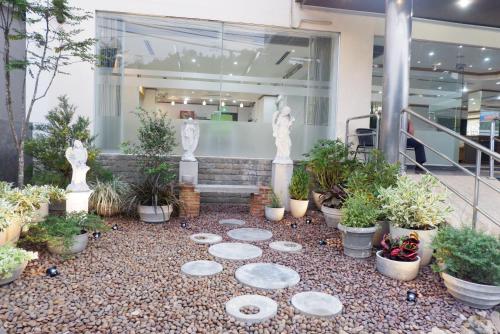 a building with a bunch of potted plants in front at Auychai Grand Hotel in Lang Suan