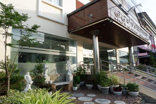 a building with plants in front of it at Auychai Grand Hotel in Lang Suan
