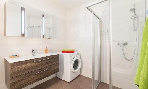 a bathroom with a washing machine and a shower at Ski In Ski Out Apartment Fastenberg Top 2 by AA Holiday Homes in Schladming