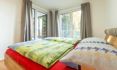 a bedroom with two beds and a window at Ski In Ski Out Apartment Fastenberg Top 2 by AA Holiday Homes in Schladming