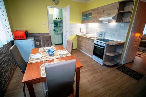 a kitchen with a wooden table and a dining room at Krisztina Apartman in Nagykanizsa