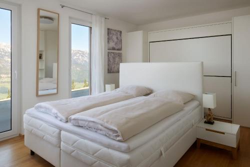 斯拉德明的住宿－Ski In Ski Out Apartment Fastenberg Top 3 by AA Holiday Homes，白色卧室设有一张大床和大窗户