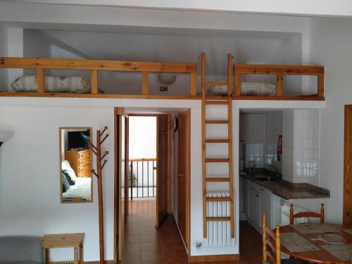 a room with two bunk beds and a kitchen at Apartaments Casa Vella Popaire in Soldeu