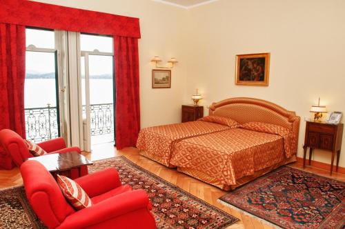 a bedroom with a bed and red furniture and windows at Villa Claudia dei Marchesi Dal Pozzo in Belgirate