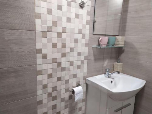 La salle de bains est pourvue d'un lavabo et d'un miroir. dans l'établissement Къща за гости Фолис, à Kyustendil