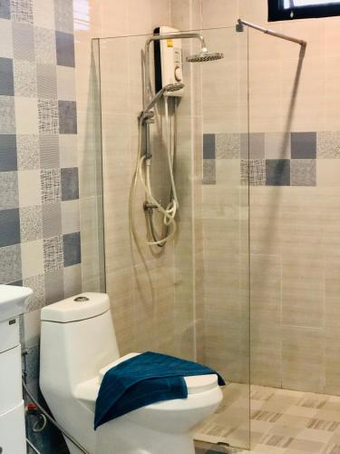 a bathroom with a shower and a toilet with a blue towel at My PoolVilla Cha am in Cha Am