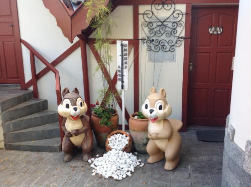 two stuffed animals sitting in front of a building at Pousada dos Esquilos in Campos do Jordão