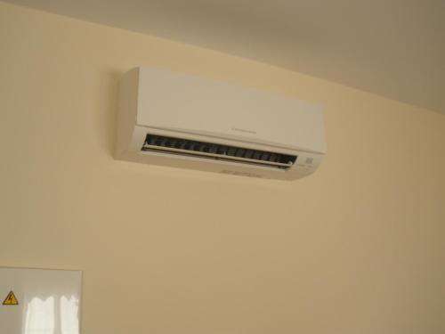 a white air conditioner hanging from a ceiling at Pensión Residencial Platas in O Pedrouzo