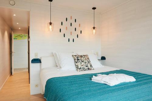 ein Schlafzimmer mit einem Bett mit einer blauen Decke in der Unterkunft B&B Armalot by Julia in De Panne