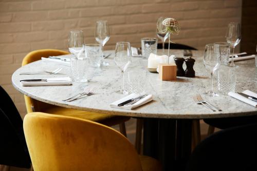 a table with wine glasses and silverware on it at B&B Armalot by Julia in De Panne