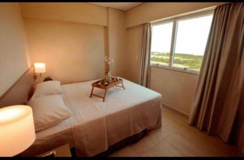 1 dormitorio con cama y ventana grande en apartamento em SALINAS RESORT, en Salinópolis