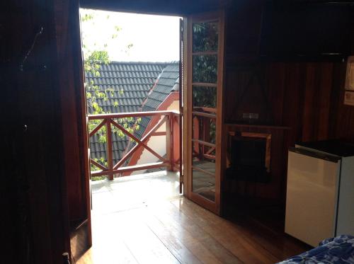 an open door to a balcony with a view at Pousada dos Esquilos in Campos do Jordão