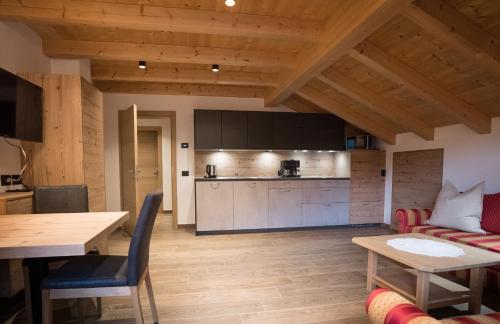 a living room with a table and a kitchen at Lüch de Crusteles in La Valle