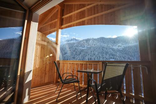 a room with a table and chairs on a balcony at Lüch de Crusteles in La Valle