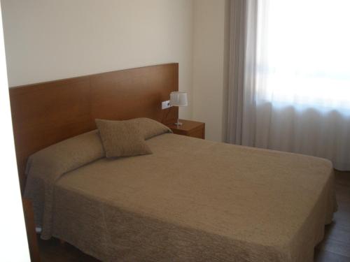 a bedroom with a bed and a window at Pensión Residencial Platas in O Pedrouzo