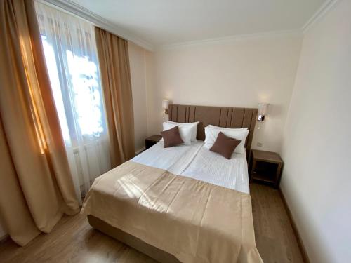 ein Schlafzimmer mit einem großen Bett und einem Fenster in der Unterkunft Alva Hotel & Spa in Zaghkadsor
