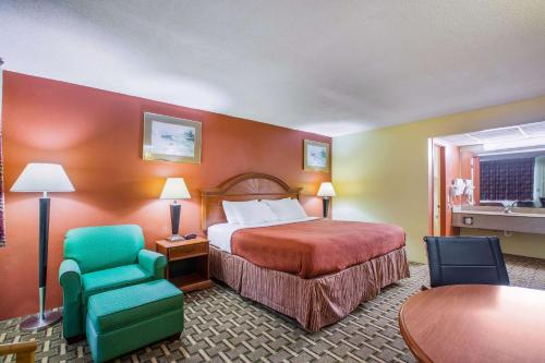 Habitación de hotel con cama, silla y mesa en Rodeway Inn, en Bonifay