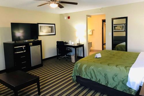 Habitación de hotel con cama y escritorio en Quality Inn & Suites, en West Monroe