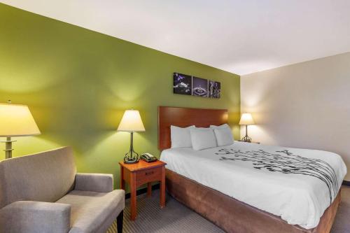 a hotel room with a bed and a chair at Sleep Inn & Suites Jacksonville West in Jacksonville