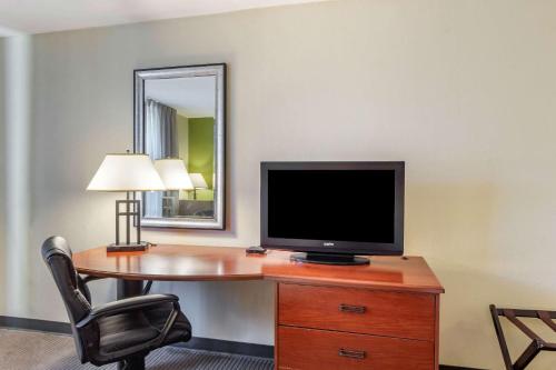 a room with a desk with a television and a chair at Sleep Inn & Suites Jacksonville West in Jacksonville